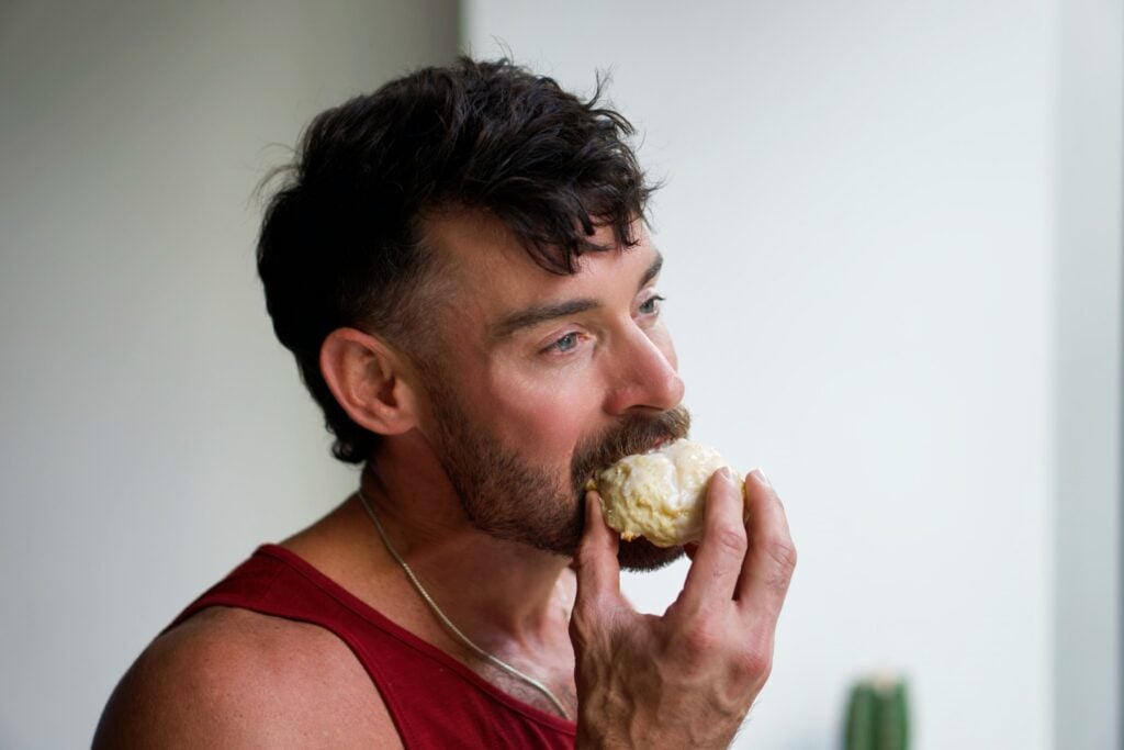 Jacob Hensley taking a bite of a cookie from a fresh batch.