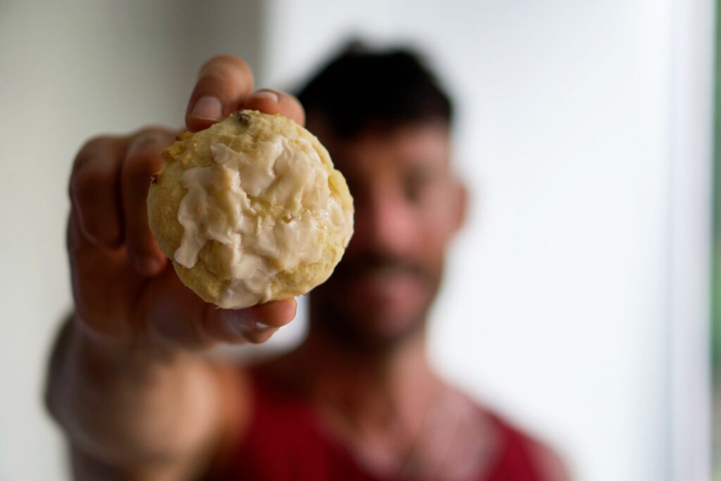 Jacob Hensley holding up a cookie to show its texture and appearance.