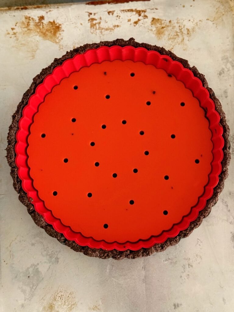 Unmolded low-carb chocolate almond flour tart crust after baking.