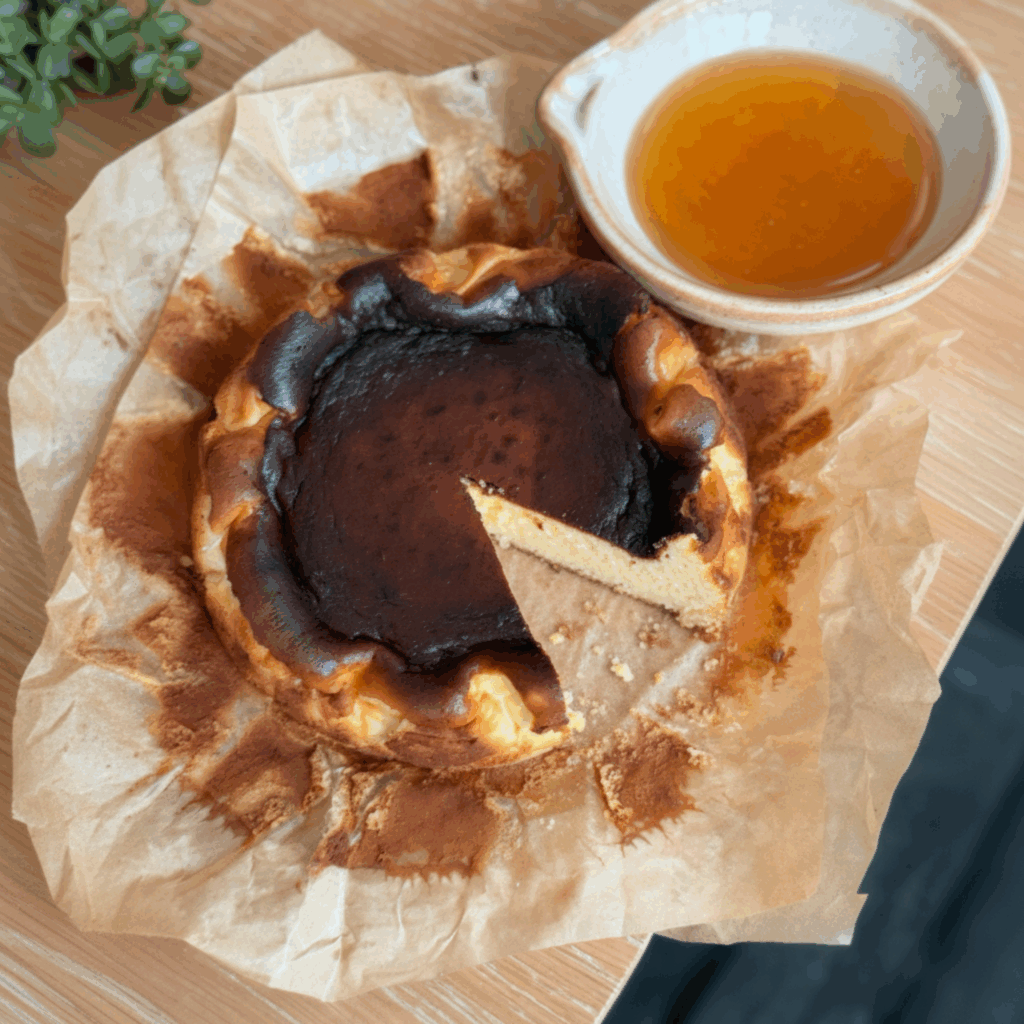 Top-down view of a perfectly baked burnt honey Basque cheesecake with a dark caramelized center.