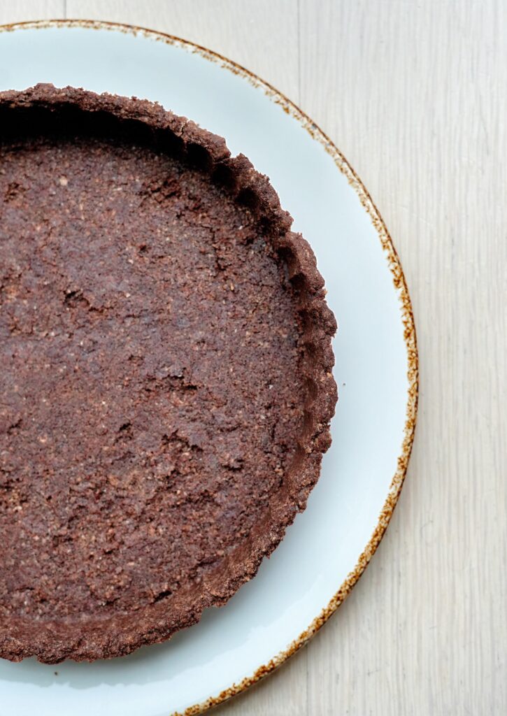 Close-up of baked low-carb chocolate almond flour tart crust texture.