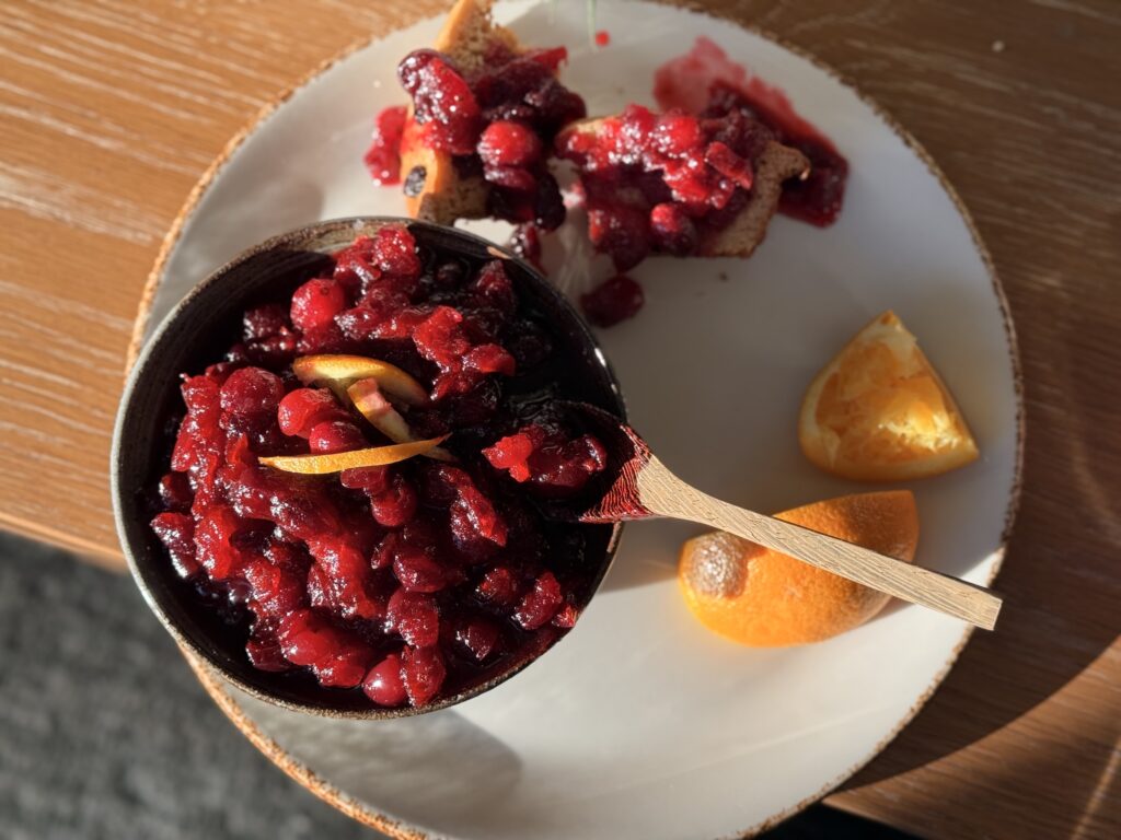 Close-up of thick homemade bourbon cranberry sauce with lemon peel