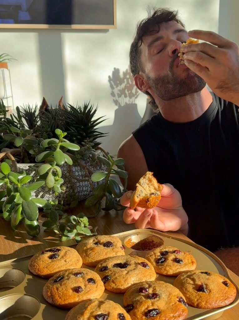 Jacob holding a plate of cranberry protein muffins in the kitchen