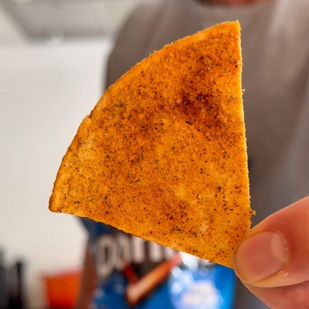 Close-up of a crispy homemade Cool Ranch Dorito with golden edges and bold seasoning.
