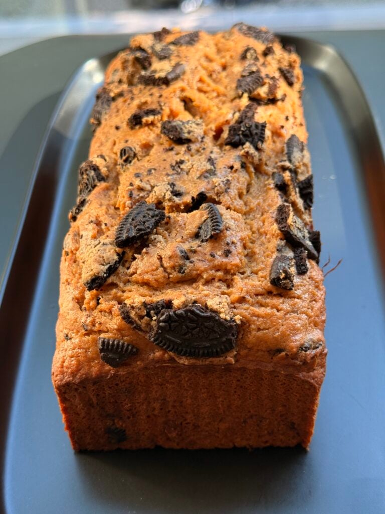 High-protein Oreo loaf cake sliced on a parchment-lined baking sheet

