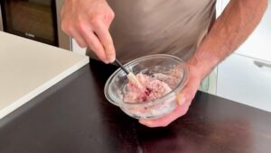 Mixing cranberry cottage cheese scone dough with a fork in a glass bowl