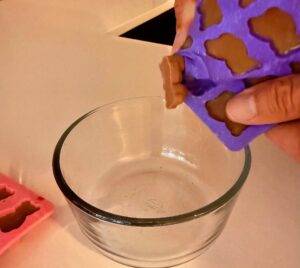 removing homemade protein gummies from silicone mold into a bowl