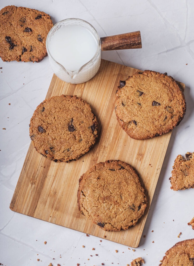 Stack of vegan chocolate chip cookies next to a glass of milk