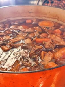 Beef and lamb stew simmering in a Dutch oven