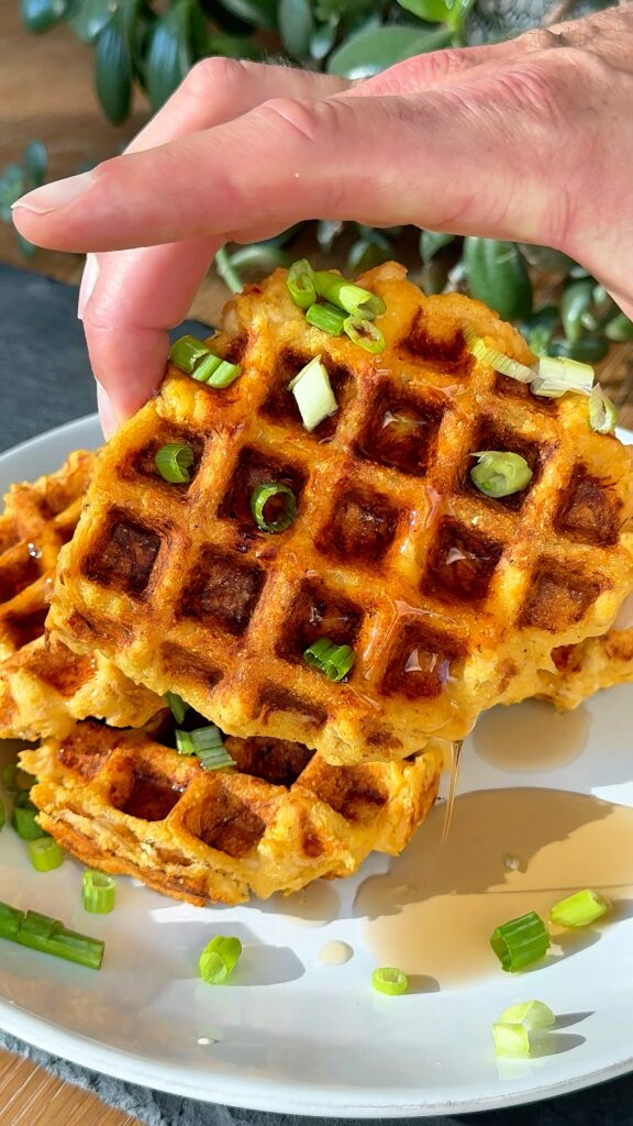 Close-up of buffalo chicken cornbread waffles with crispy edges and green onions