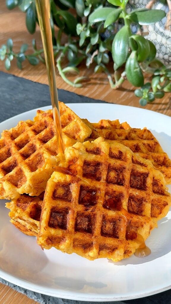 Buffalo chicken cornbread waffles drizzled with sauce and topped with green onions