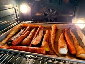 Carrots roasting in the oven on a baking tray