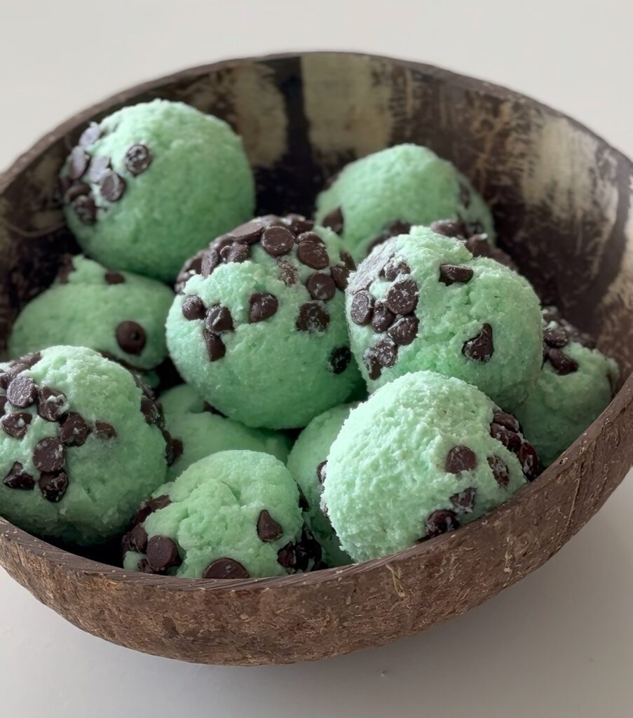Extreme close-up shot showing the soft, edible texture and visible mini chocolate chips in the mint-flavored protein cookie dough.
