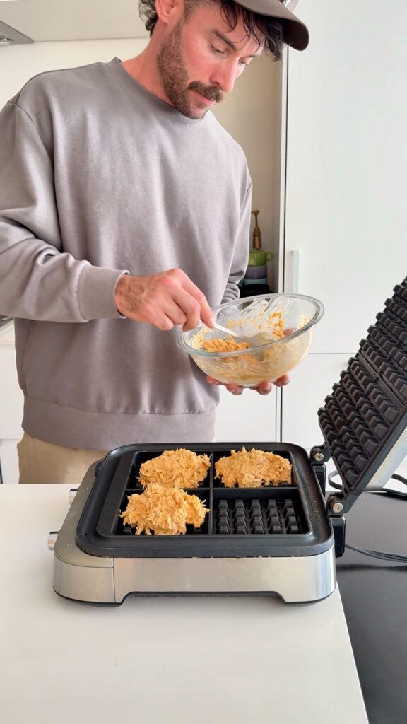 Cornbread waffle batter being poured into waffle iron
