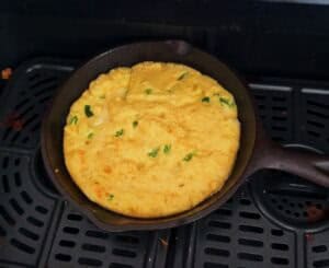 Unbaked cornbread protein batter in a personal cast iron skillet, ready for oven or air fryer