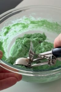 Mixing wet ingredients like butter substitute, Greek yogurt, and mint extract to form the creamy base of the edible cookie dough.