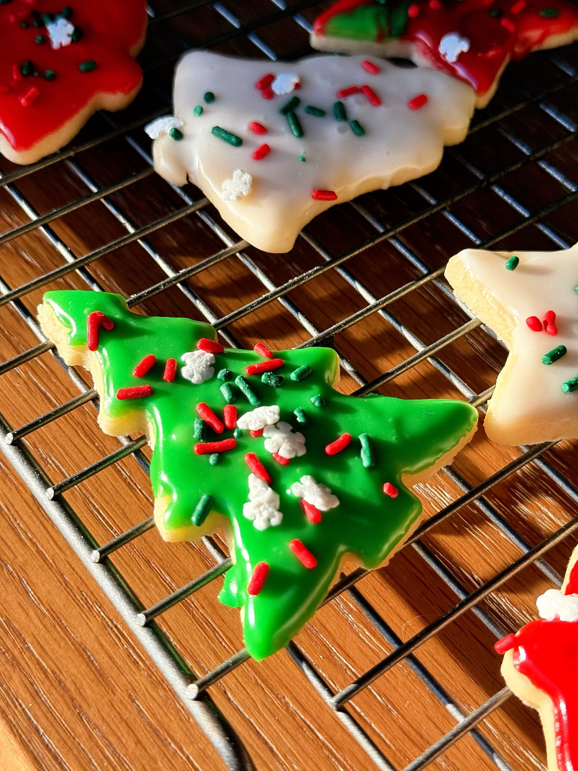 Decorated vintage sour cream cut out cookies on cooling rack