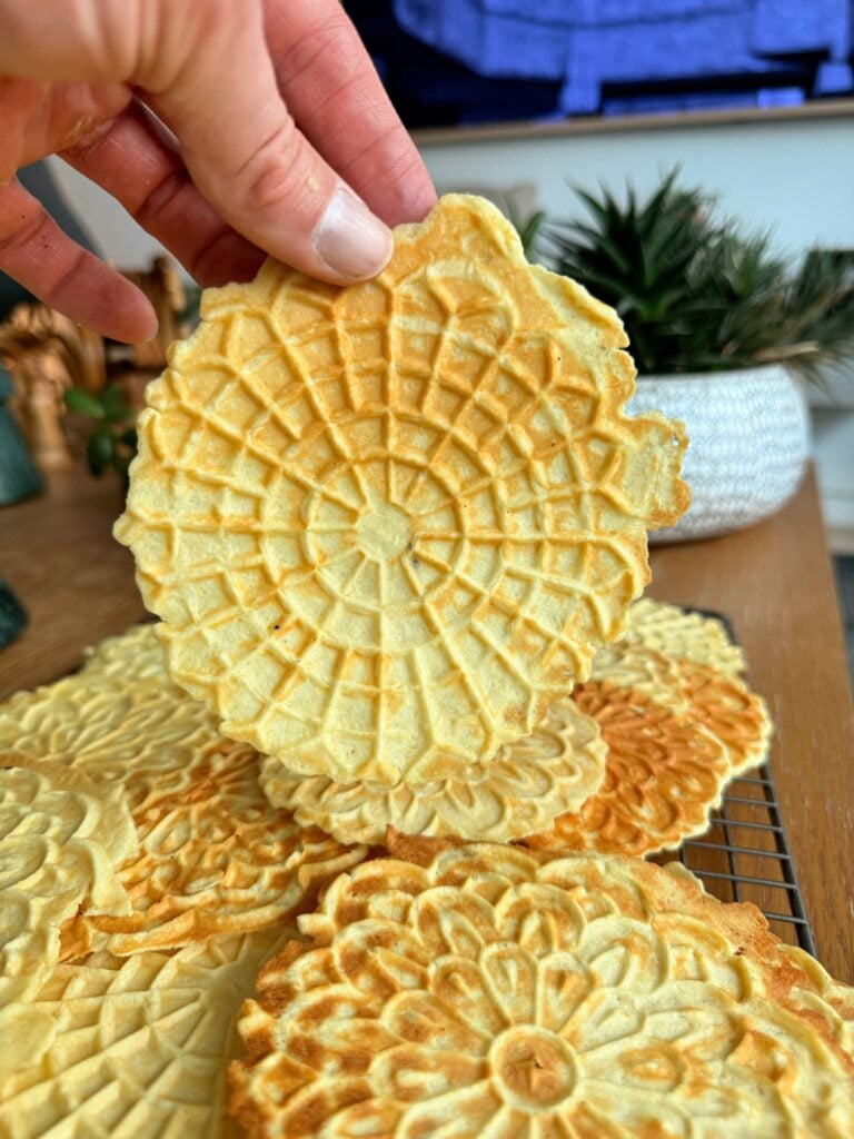High protein pizzelle cookie held in hand