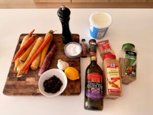 Ingredients for harissa and maple roasted carrots including spices, yogurt, and carrots