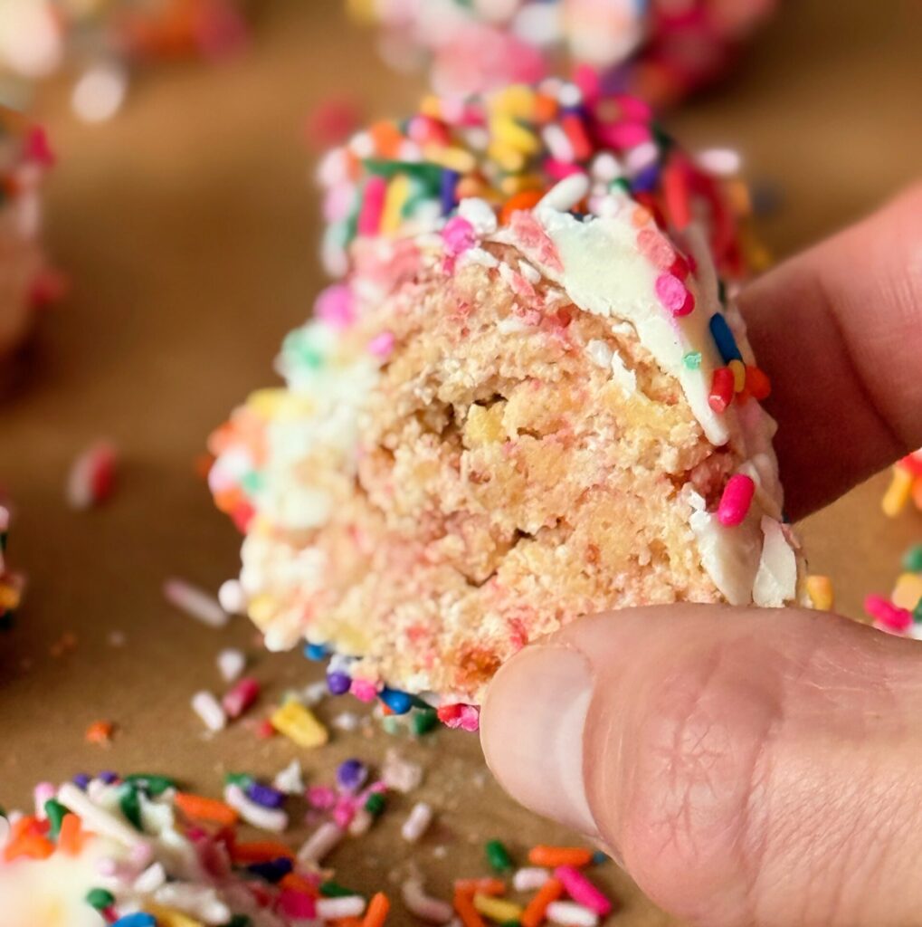 Close-up of the inside of a sprinkled cake pop being held