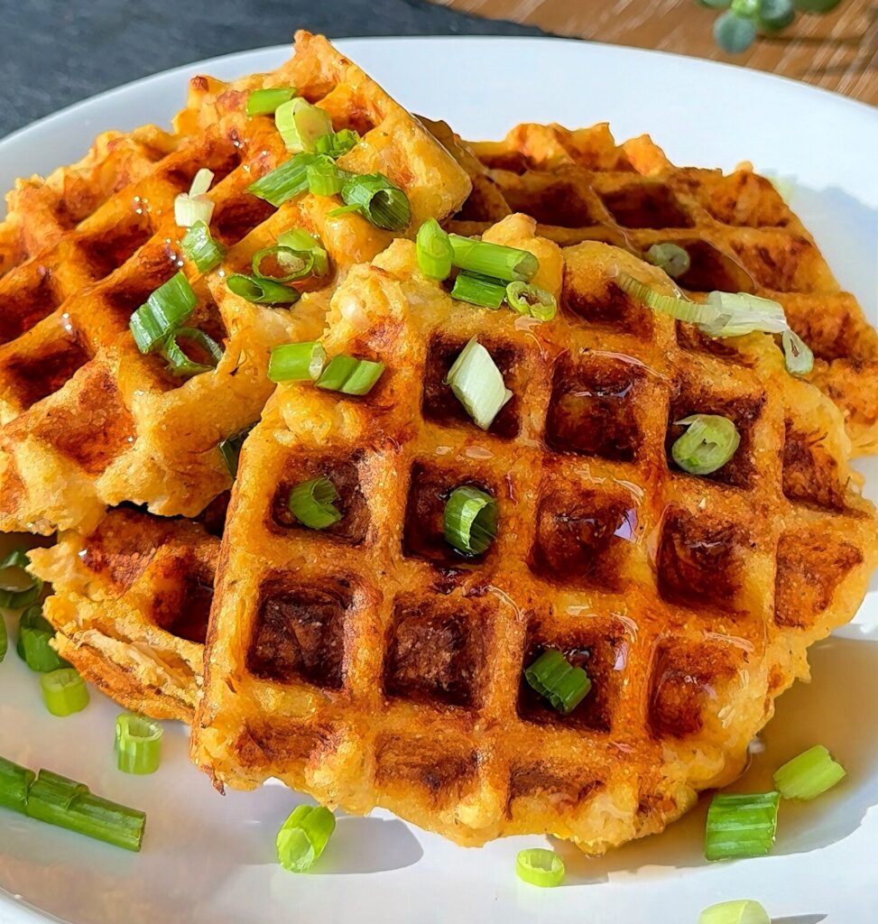 Plated buffalo chicken cornbread waffles topped with green onions