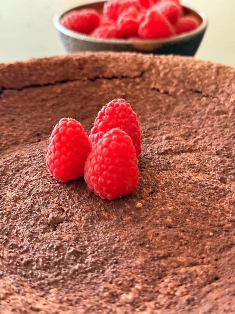 Fresh raspberries on top of torta caprese chocolate cake
