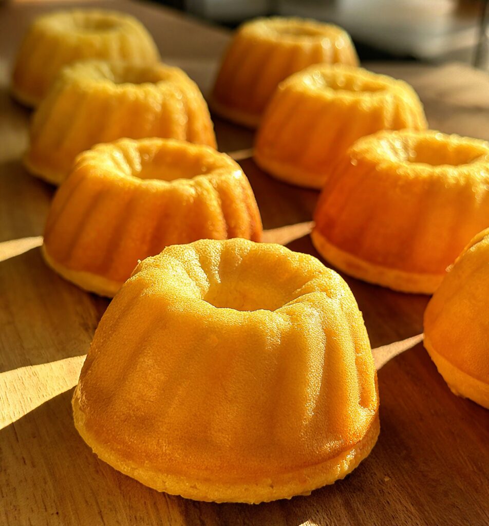 Cluster of several small, golden high-protein whole orange mini Bundt cakes ready to be served.