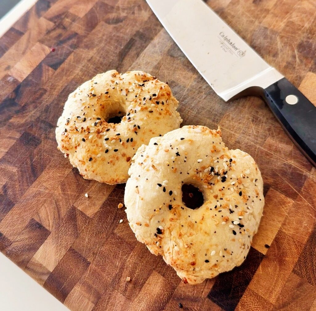 Finished gluten-free cottage cheese bagels resting on wooden cutting board