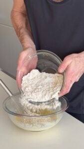 Adding dry ingredients into wet ingredients for high protein snickerdoodle muffin batter