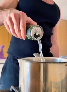 Energy drink being poured into a pot to make homemade gummy worms