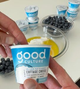 man eating cottage cheese blueberry muffin with Good Culture cottage cheese