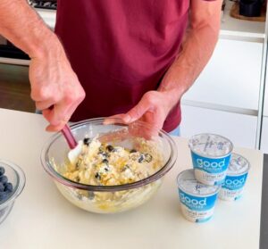 mixing cottage cheese blueberry muffin batter in bowl