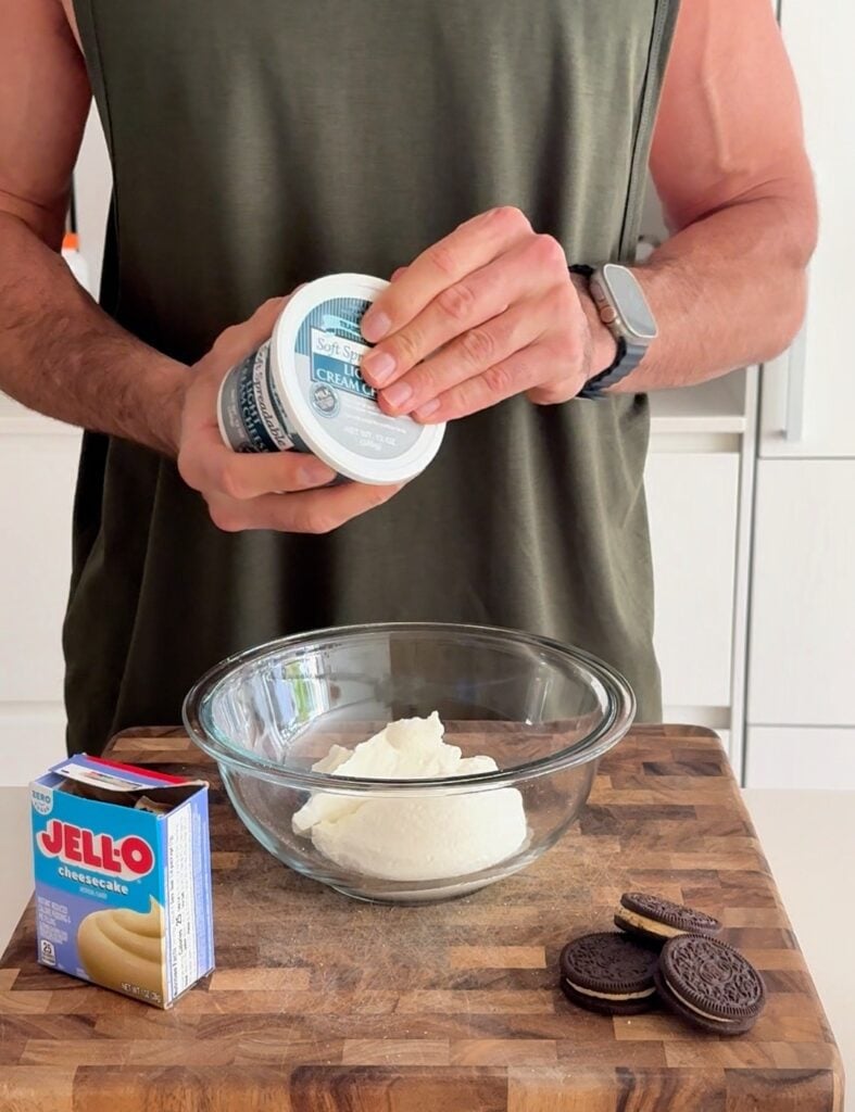 Ingredients being added to a bowl for an Oreo cheesecake protein bowl