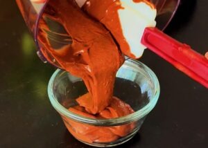 pouring blended chocolate cottage cheese mixture into bowl