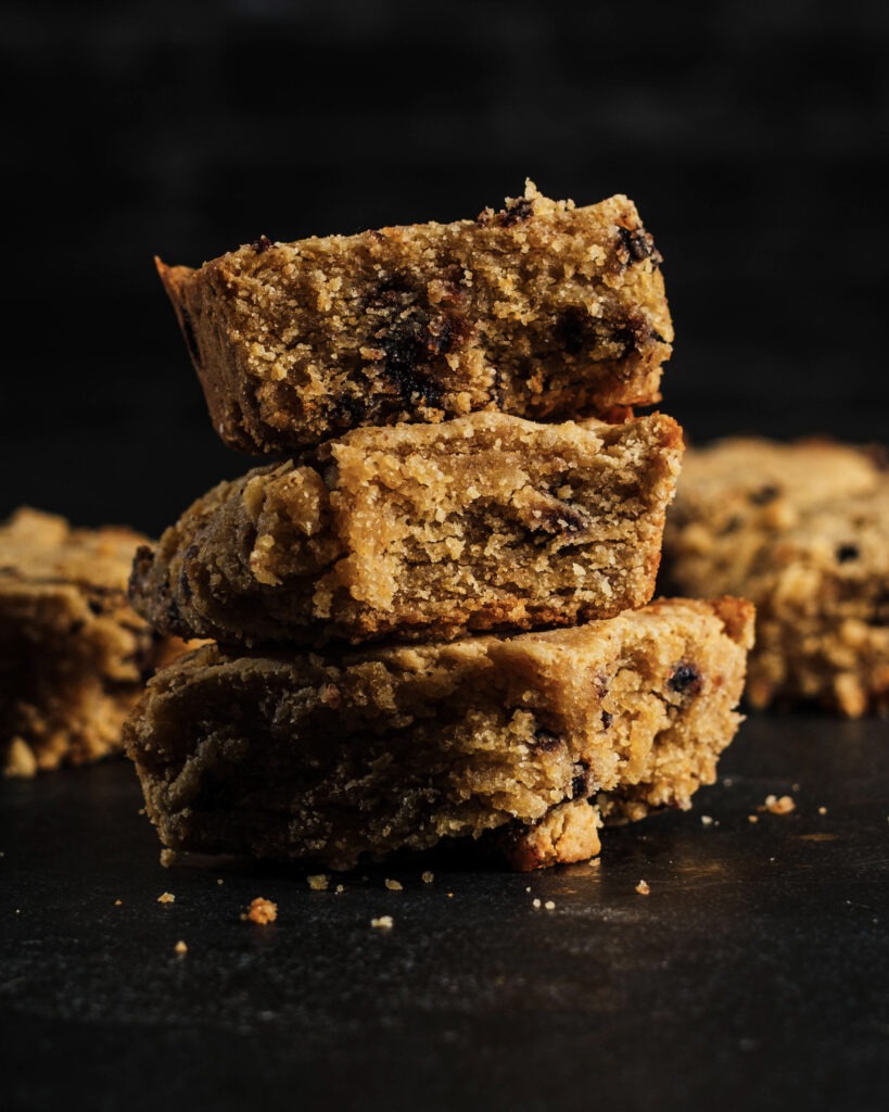 High-protein gluten-free blondies stacked on dark surface