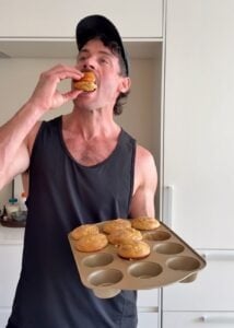 Taking a bite of a high protein snickerdoodle muffin