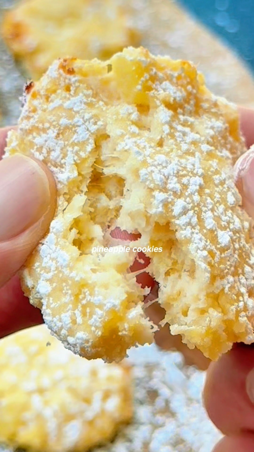 Broken open pineapple cookie showing soft, moist interior texture