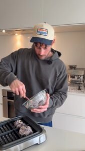 stirring high protein blueberry waffle batter in bowl