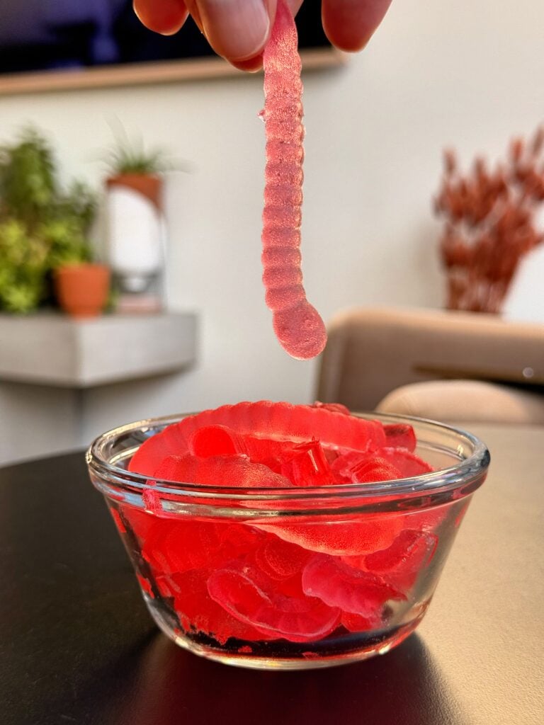 Energy drink gummy worm being lifted from the bowl