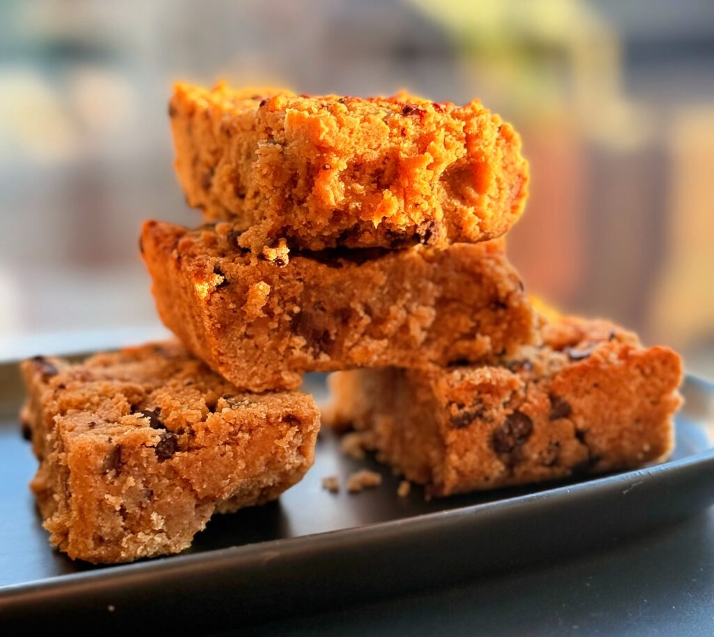 and pulling apart a peanut butter protein blondie to show inside