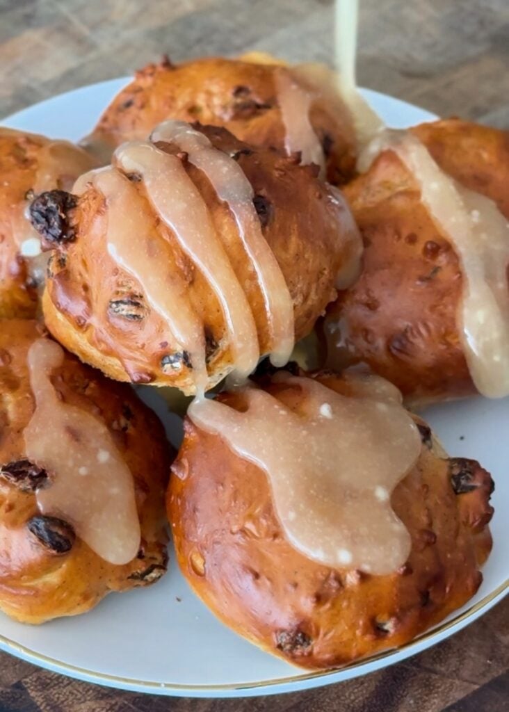 A bowl of high-protein cinnamon raisin bagel bites served next to a small dish of vanilla Greek yogurt cream cheese dip.