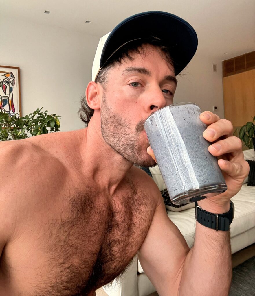 Jacob drinking a homemade blueberry spinach smoothie in natural light