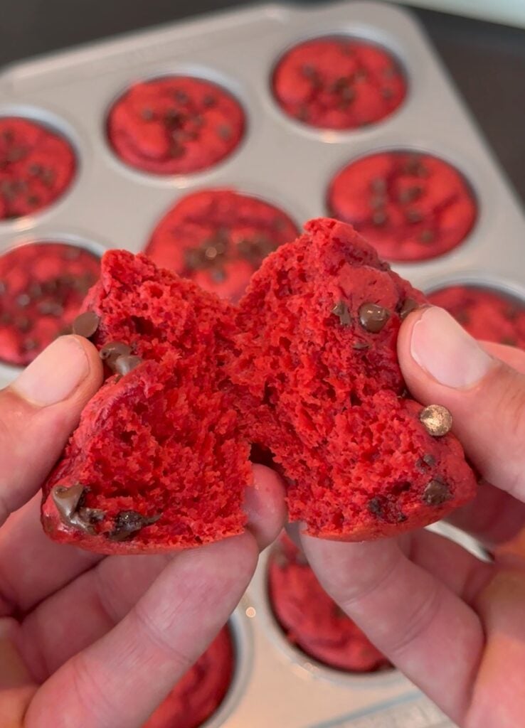 Inside of a red velvet protein cupcake showing soft texture and chocolate chips