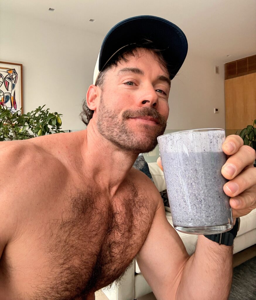 Jacob, founder of BakedLean, drinking a high fiber blueberry spinach shake