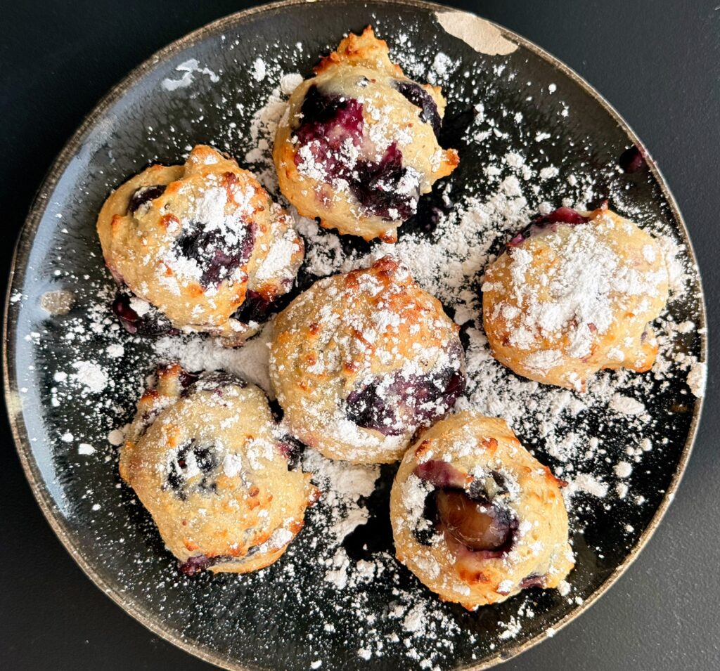 Plate of lemon blueberry air fryer donut holes dusted with powdered sugar