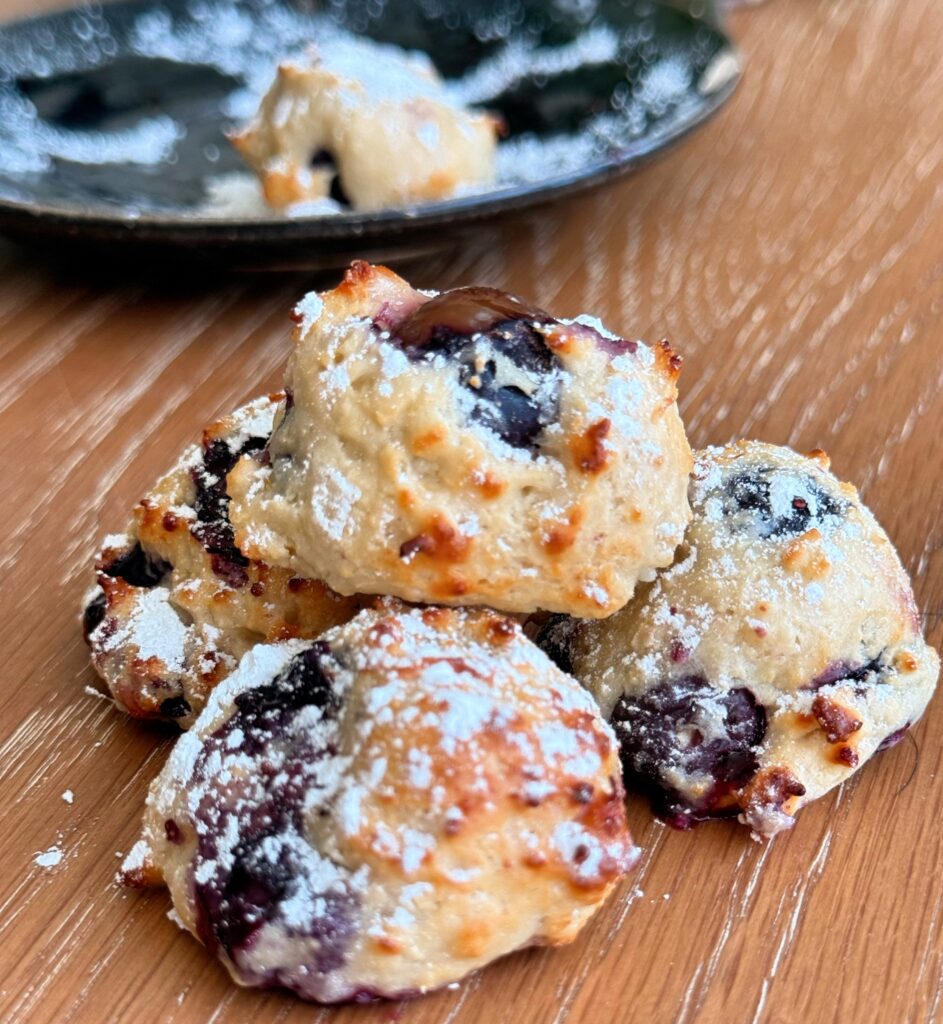 Stack of lemon blueberry air fryer donut holes with powdered sugar