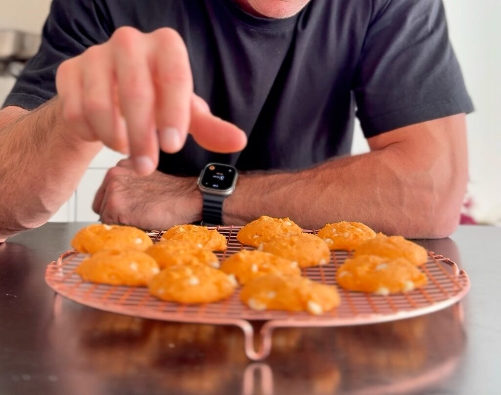 High Protein Orange Cookies on Tray with Hand