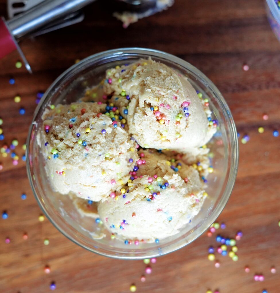 A bowl of edible high protein cookie dough with sprinkles.