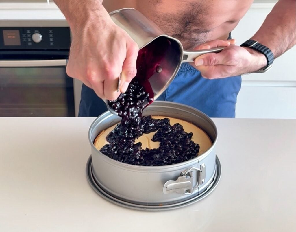 pouring topping over cheesecake