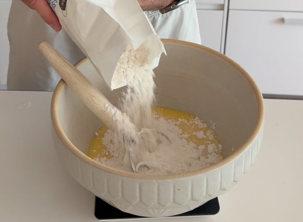 adding flour to orange juice and starter
